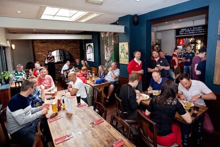 A group of people in the pub - some wearing Wales rugby tops