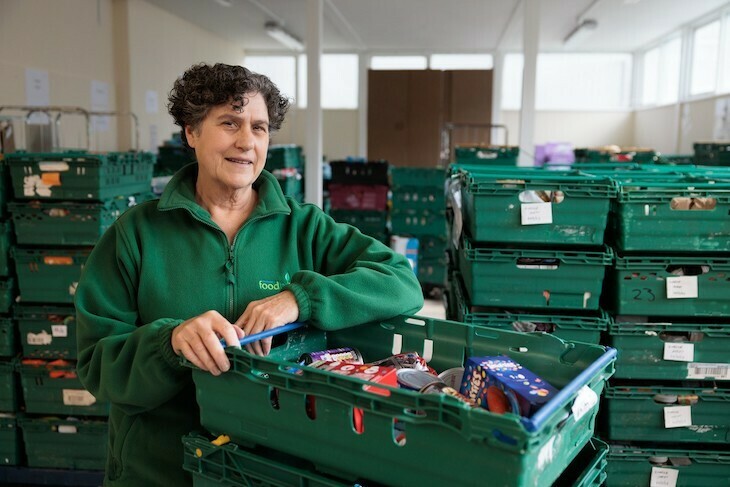 A foodbank volunteer in green clothes