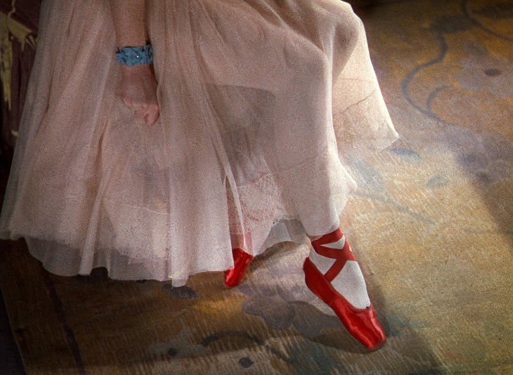 A still from film The Red Shoes, featuring someone wearing a red pair of ballet shoes