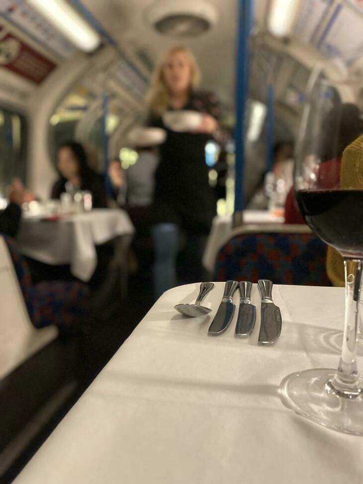 Tube Supperclub:  A table neatly laid out - with a waitress in the background bringing food